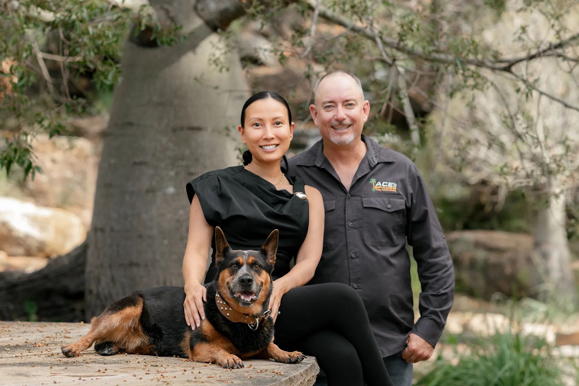 Russell, his wife Aimee, and their dog Ace in front of a bottle tree